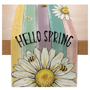 Linen table runner detail showing hand-painted daisies, honey bees, and Hello Spring text