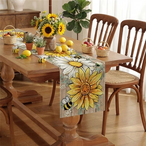 Linen table runner with sunflower daisy and bee prints on a rustic wooden dining table
