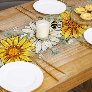 Linen table runner with sunflower, daisy, and bee prints on a rustic wooden table
