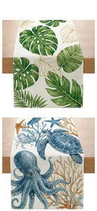 Detail view of floral and ocean themed cotton linen table runners on wood surface
