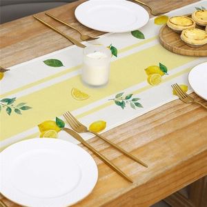 Table runner featuring yellow lemon slices and green leaves on a white and striped background