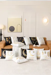 Detail of Ramadan Kareem pillow covers with gold moon and star motifs on leather sofa