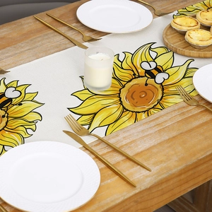 Linen table runner with sunflower and bee prints on a rustic wooden dining table