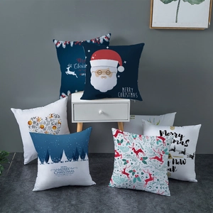 Christmas peach skin pillowcases with Santa and reindeer prints on a white nightstand