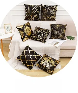 Close-up of luxury black and gold throw pillows with geometric foil print patterns on a sofa