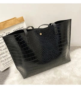 Détail du sac cabas noir à motif crocodile avec fermeture à bouton pression magnétique