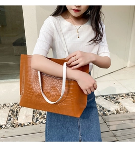Détail du sac cabas marron à motif crocodile avec anses blanches contrastantes