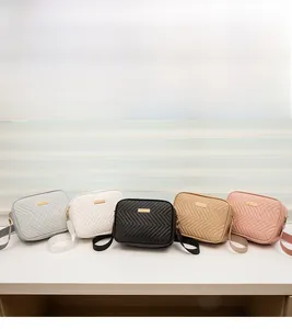 Close-up of five quilted camera bags in various colors with wide straps and gold hardware