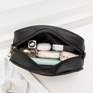 Minimalist black PU leather camera bag with gold zipper showing daily essentials storage