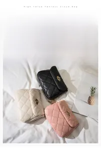 Close-up of three quilted cloud bags in white, black and pink with gold oval twist locks