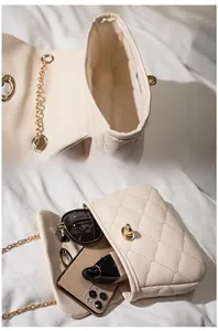 Quilted cream chain bag showing interior storage space for phone and makeup