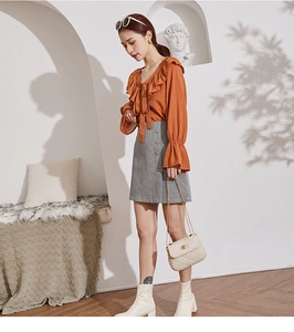 Chic beige quilted chain crossbody bag paired with an autumn orange ruffled shirt outfit