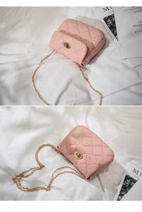 Detail of pink quilted texture and gold turn-lock closure on chain shoulder bag