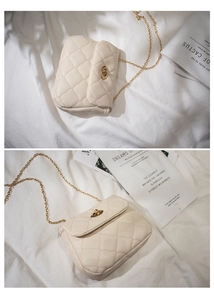 Close-up of beige quilted chain bag with gold rotary lock and diamond stitching