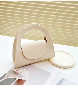 Détail du mini sac à main blanc crème avec texture lychee premium et poignée ronde