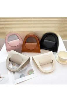 Vue à plat de cinq mini sacs à main en cuir en rose, marron, noir, gris et blanc