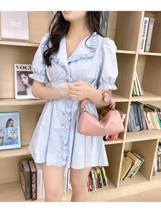 Pink pleated pillow bag with gold chain strap shown on a model in a library