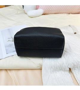 Detail of black lychee grain leather pillow bag showing the reinforced flat bottom base
