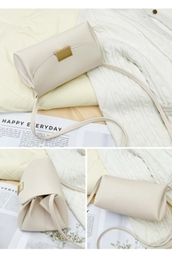 Detail of cream lychee texture crossbody bag with gold magnetic buckle and slim strap