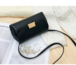 Macro detail of black litchi grain leather bag with elegant gold metal buckle hardware