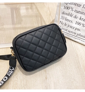 Detail of black quilted camera bag with gold zipper and stylish NEW CITY canvas strap
