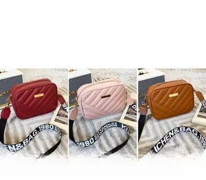 Three quilted cross-body camera bags in red, pink, and brown with letter print straps