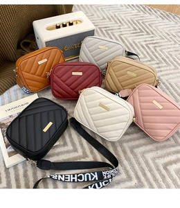Detail of colorful quilted PU leather crossbody bags with embroidered fashion straps