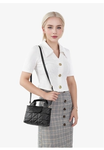 Détail du sac seau noir matelassé avec bandoulière réglable porté par un mannequin