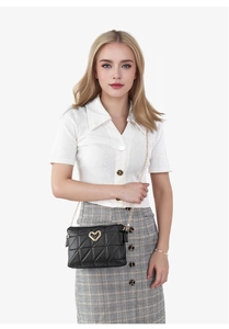 Model wearing a black quilted chain bag with gold heart-shaped lock and diamond pattern