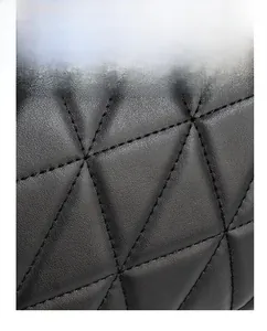 Macro shot of black quilted leather handbag with geometric triangle stitching detail