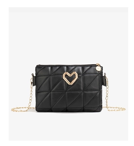 Close-up of black quilted PU leather bag featuring a golden heart-shaped metal logo