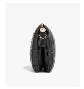Detail of black quilted leather handbag showing double gusset and gold zipper hardware