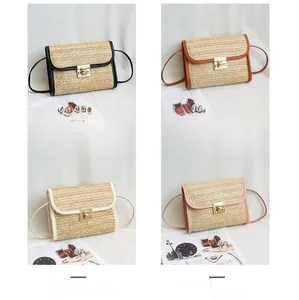 Detail view of woven straw mini bags in black, brown, cream, and pink with metal buckle