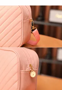 Detalle del bolso acolchado rosa con hebillas doradas y sistema de cremallera metálica