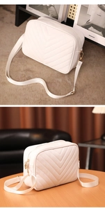 Detalle del bolso de cámara en cuero acolchado blanco con cremallera dorada