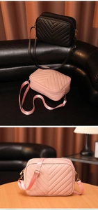Detalle de bolsos negros y rosas con diseño acolchado en V y correas de tejido ancho