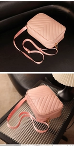 Detalle de bolso cámara rosa con costuras en V, correa ancha y herrajes dorados