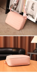 Primer plano de bolso rosa con costuras en V y hebilla dorada ajustable