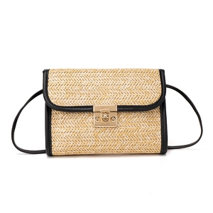 Straw crossbody bag with black faux leather trim and gold metal clasp on white background
