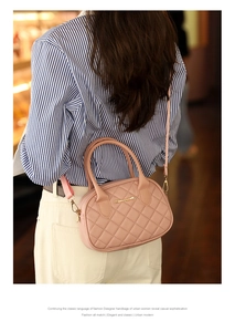 Detailed view of pink quilted handbag showing gold metal logo and sleek top zipper