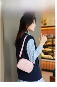 Sac bandoulière rose avec broderie vagues et bandoulière ajustable sur modèle