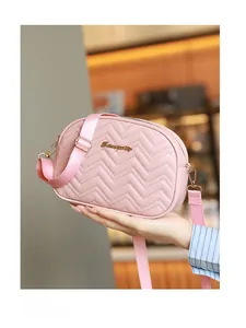 Détail du sac matelassé rose clair avec crochets dorés et bandoulière réglable