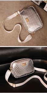 Detail der silbernen Metallic-Umhängetasche mit Webstruktur und weißem breitem Gurt