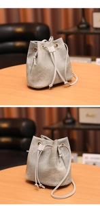 Détails du sac seau gris avec fermeture à cordon et œillets métalliques dorés