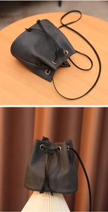 Détail du sac seau montrant les cordons de serrage et les œillets dorés sur tissu gris foncé