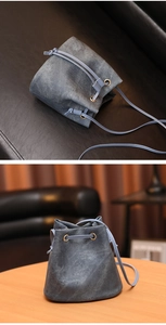Détail d'un sac seau en denim bleu avec fermeture à cordon et bandoulière en cuir