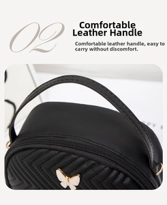 Detail of black quilted leather handbag featuring a white enamel butterfly clasp