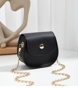 Detail of black mini crossbody bag with litchi grain texture and gold circular buckle