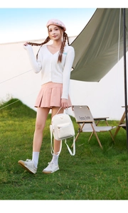 Detail of white PU leather mini backpack featuring V-quilted texture and gold butterfly logo
