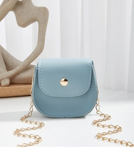 Close-up of mini light blue leather crossbody bag with gold chain and circular buckle